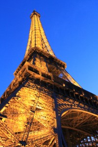 Close up photo of Eiffel tower with lights and a dusk sky